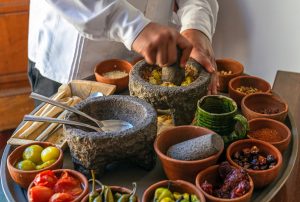 preparación de gastronomía local con diferentes ingredientes en recipientes de piedra