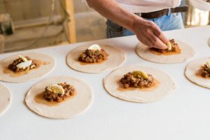Hombre cocinando empanadas de pino