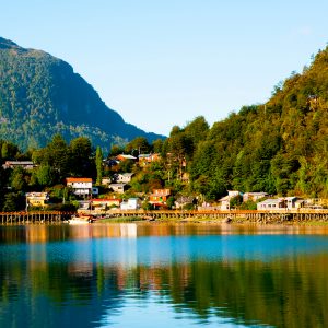 Vista panorámica de la caleta Tortel con el reflejo del paisaje en el rio Baker