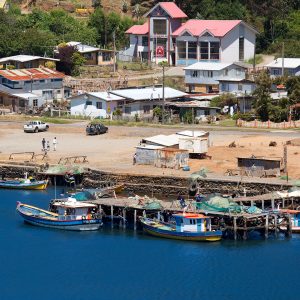 Vista a la caleta con botes pescadores y muelle en la bahía