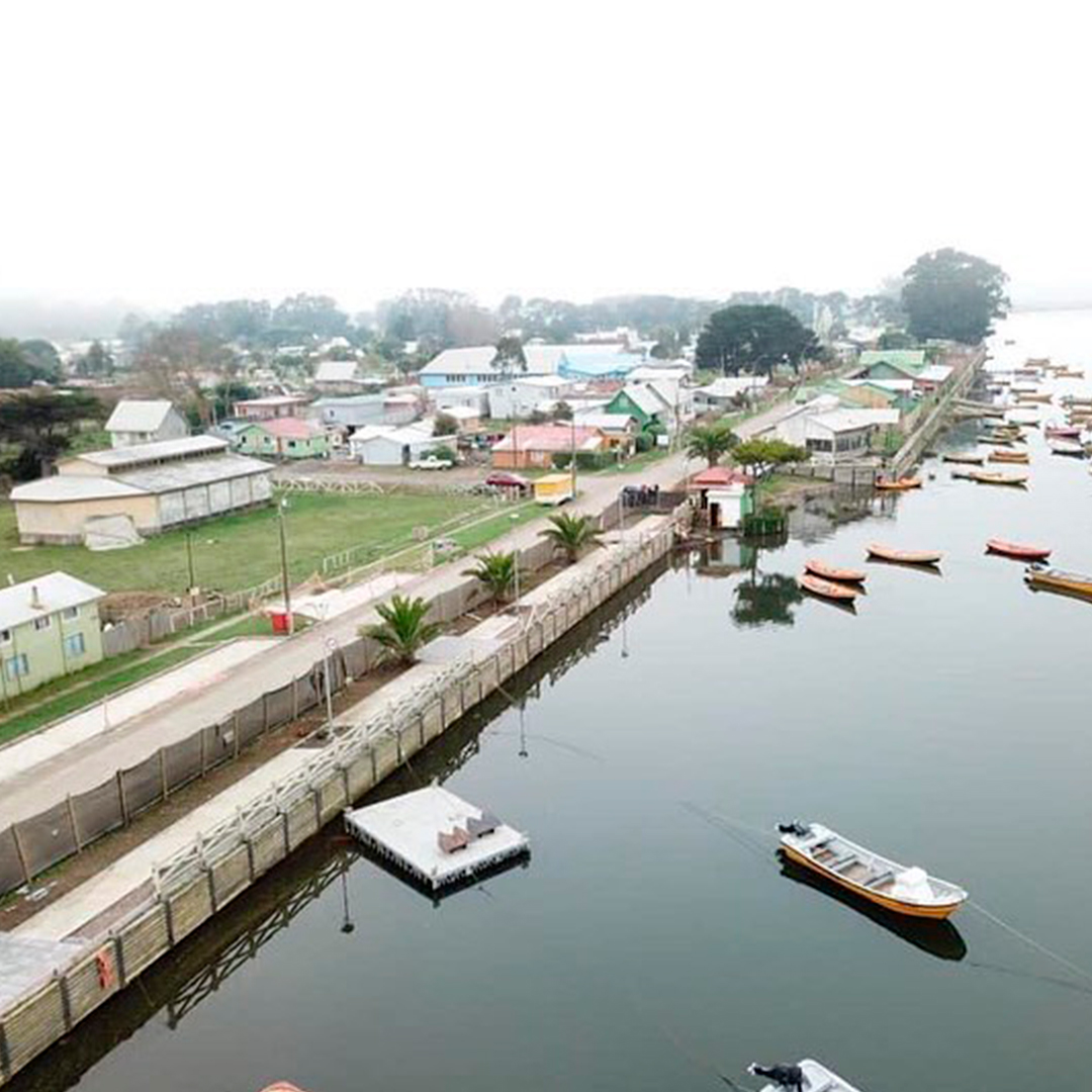 fotografia de caleta con botes de pescadores junto a casas