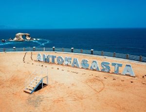 playa antofagasta con nombre de región en un cartel a lo largo de la arena con mar de fondo