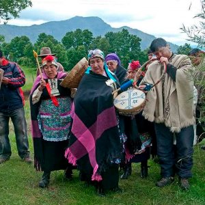 Grupo de mapuche reunidos celebrando el we tripantu mapuche con diversos instrumentos musicales típicos