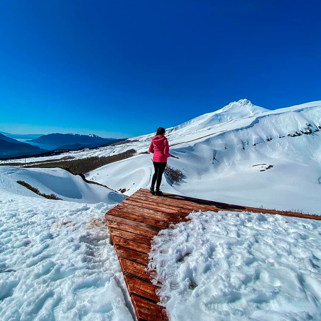 mujer caminando por sendero nevado