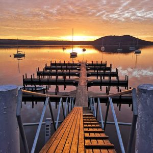 fotografía de muelle y lago en el atardecer