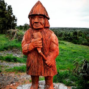 Estatua de madera de El Trauco con su hacha.