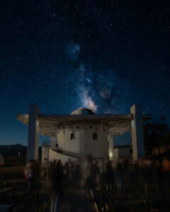 Un grupo de turistas reunido de noche junto a la estructura principal del Observatorio Mamalluca, bajo un despejado firmamento estrellado ideal para el astroturismo en la Región de Coquimbo.