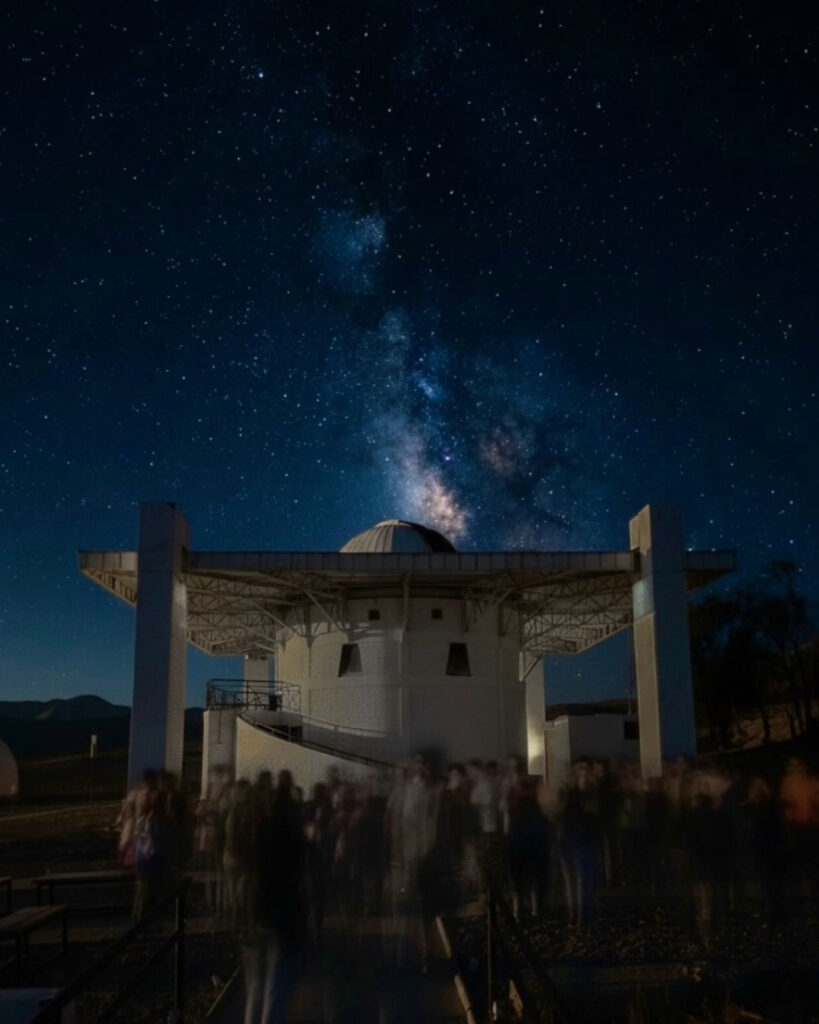 Un grupo de turistas reunido de noche junto a la estructura principal del Observatorio Mamalluca, bajo un despejado firmamento estrellado ideal para el astroturismo en la Región de Coquimbo.