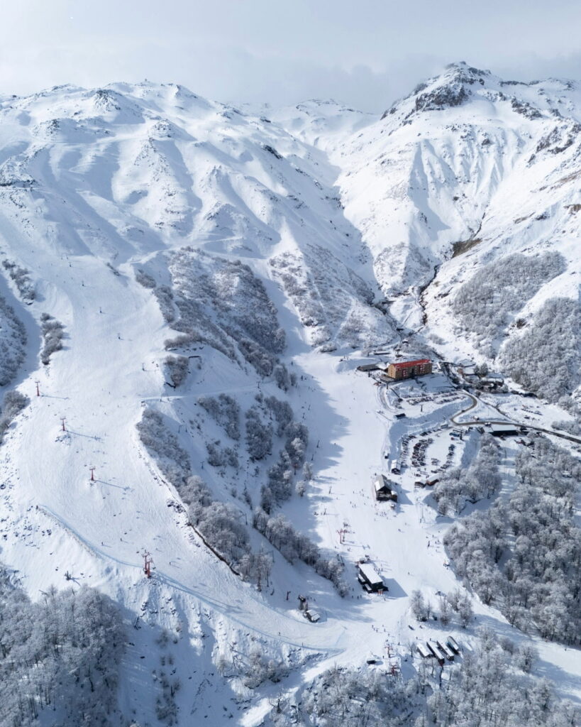 Centro de esquí Nevados de Chillán, rodeado de imponentes montañas cubiertas de nieve, ideal para disfrutar de panoramas para las vacaciones de invierno en Chile.