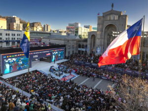 Multitud reunida en la Plaza de la Independencia de Concepción durante la ceremonia de partida del Rally Biobío 2026, con pantallas gigantes, autos de competencia y la bandera chilena ondeando.
