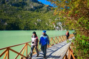 Fotografía de dos personas caminando en una pasarela en Caleta Tortel.