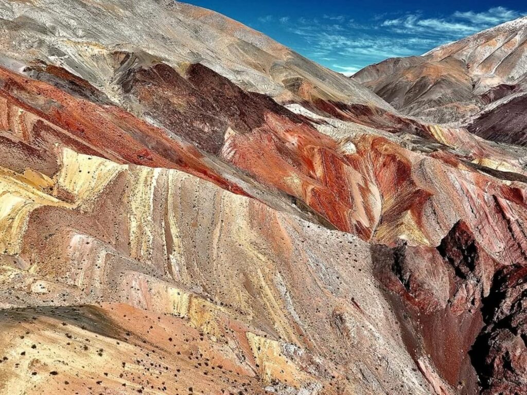 Capas de roca en tonos rojizos, ocres y blancos conforman el paisaje conocido como "Arcoíris de Atacama", cerca del pequeño poblado de Pinte. 