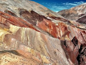 Capas de roca en tonos rojizos, ocres y blancos conforman el paisaje conocido como "Arcoíris de Atacama", cerca del pequeño poblado de Pinte.